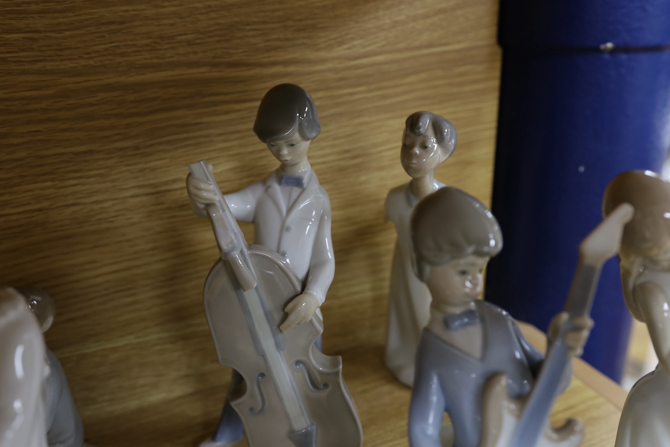 A Lladro collection: seven figures, five further damaged figures and a Lladro reference book
